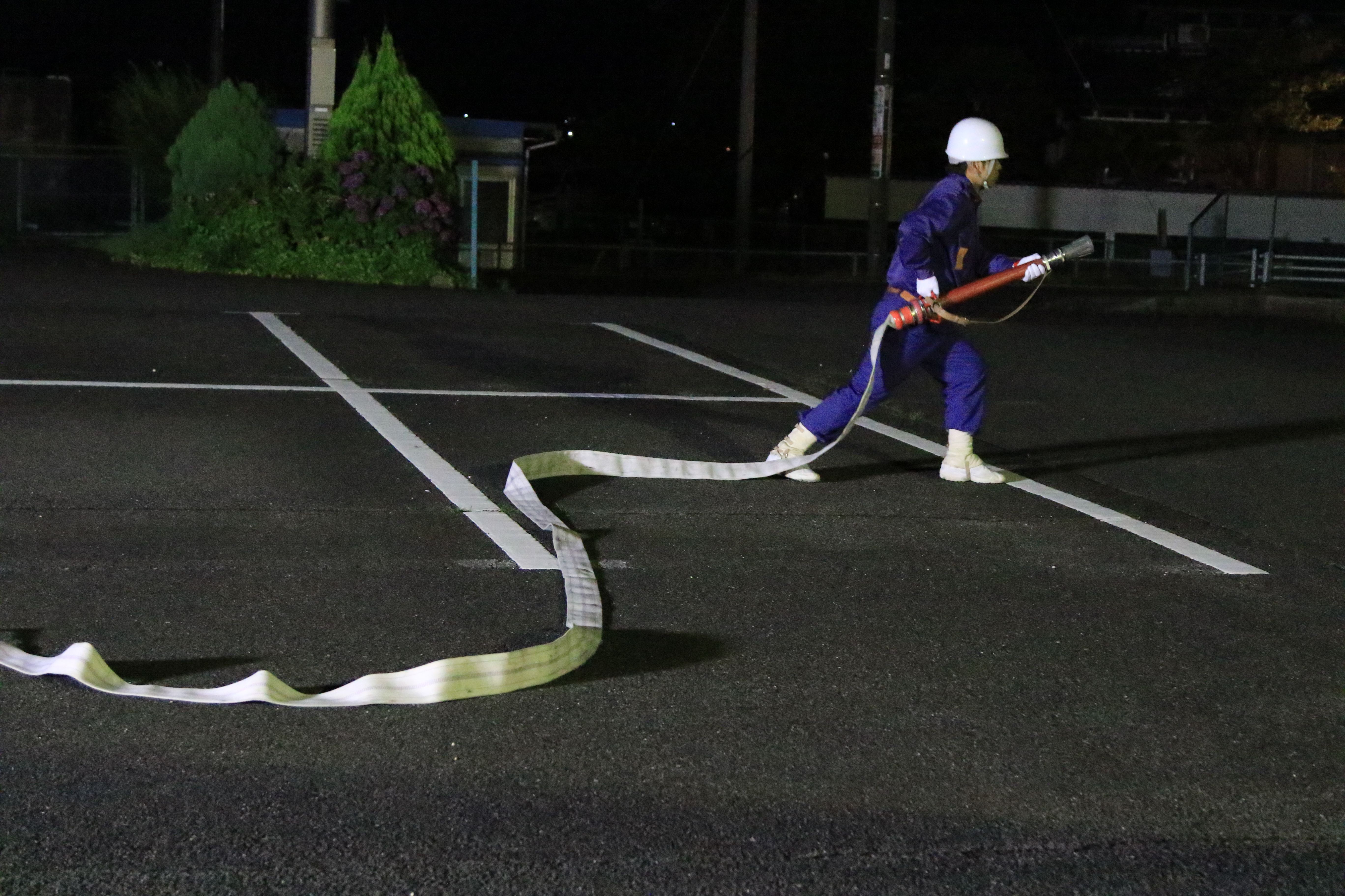 夜間に消防操法の訓練をしている写真